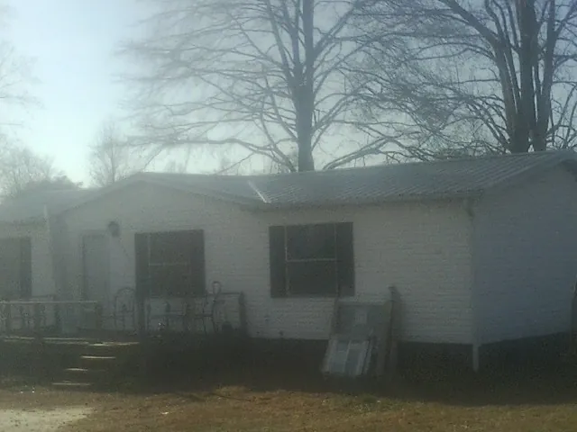 New metal roof on a white painted brick home on a foggy morning in Laurel